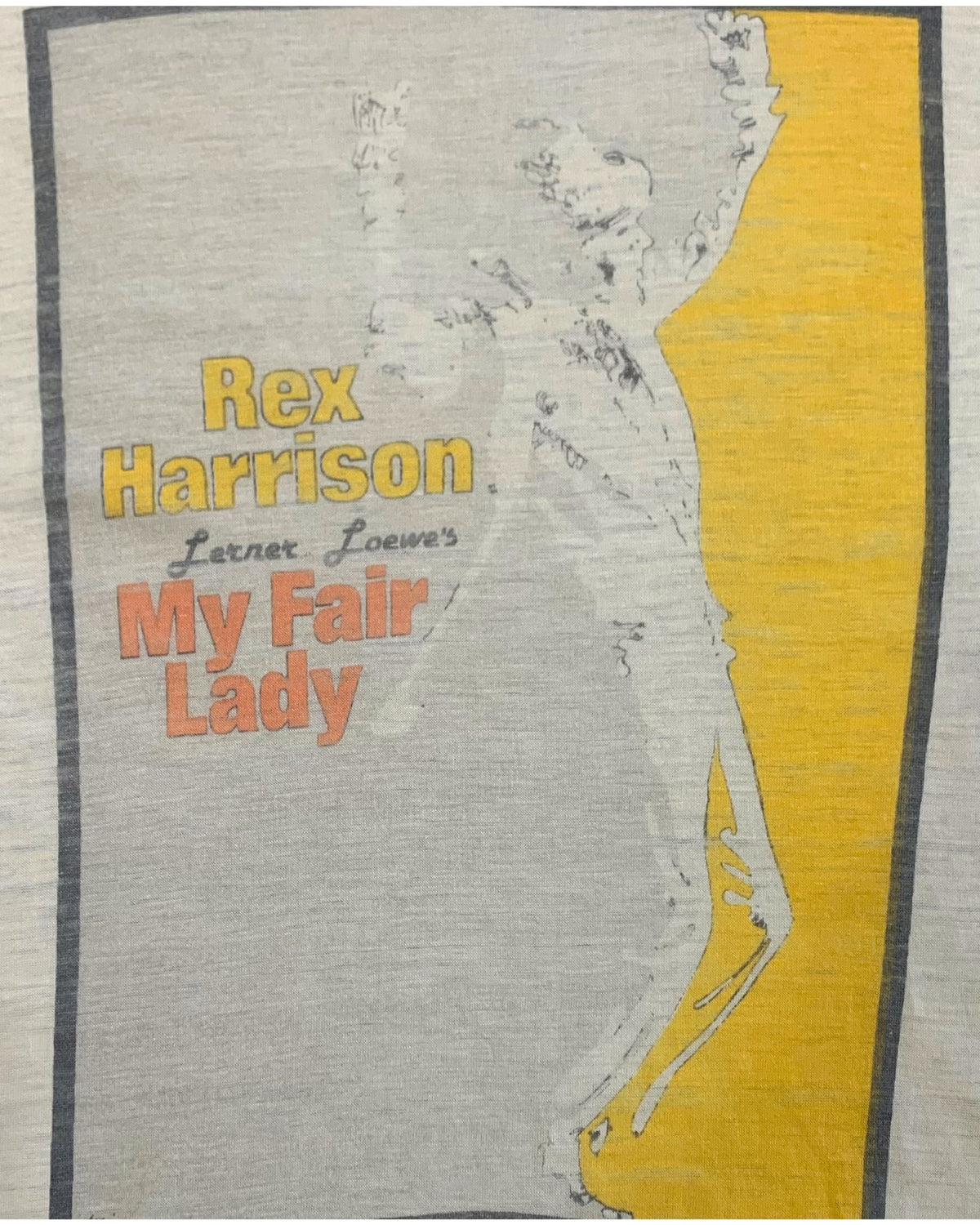 Close-up of the front graphic on a 1970s Rex Harrison My Fair Lady t-shirt displaying stylized artwork, yellow accents, and soft aging across the print.

