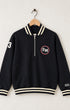 Front view of Surfing Cowboys Santa Monica Half Zip Neighborhood Sweatshirt in garment-dyed black with cream striped ribbing, red-accented SM chest patch and cream number 3 sleeve.