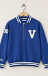Front view of a garment-dyed Venice Blue 100% cotton half-zip sweatshirt featuring a cream varsity block letter V on the chest, striped ribbing, hand pockets, and a felt 30 patch on the sleeve.