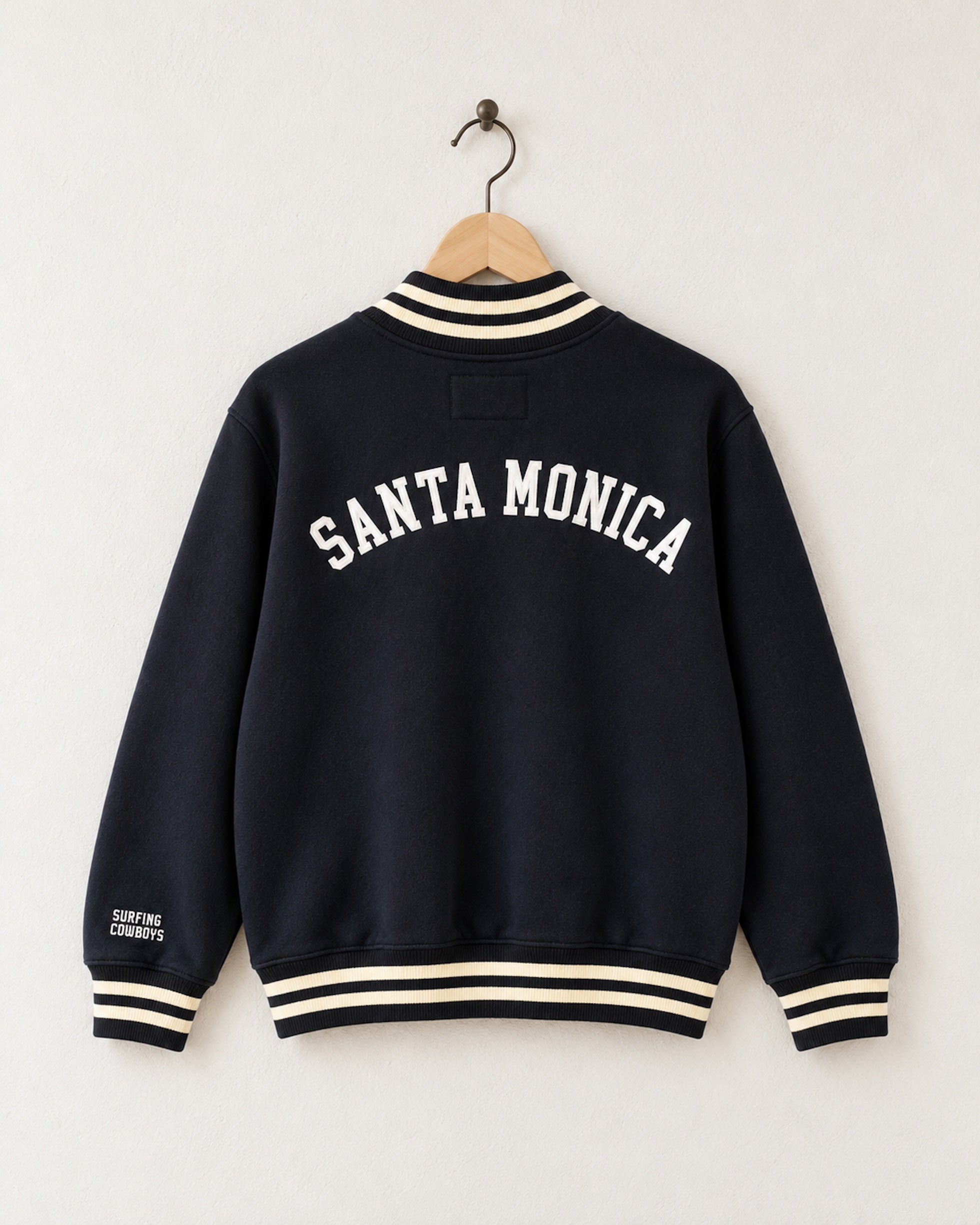 Back View of Surfing Cowboys Santa Monica Half Zip Neighborhood Sweatshirt in garment-dyed black with cream striped ribbing, Santa Monica Lettering on the back and Surfing Cowboys embroidered on the sleeve.