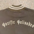 Close-up view of the striped cream and brown ribbed neck and the back featuring cream Surfing Cowboys branding centered and embroidered.
