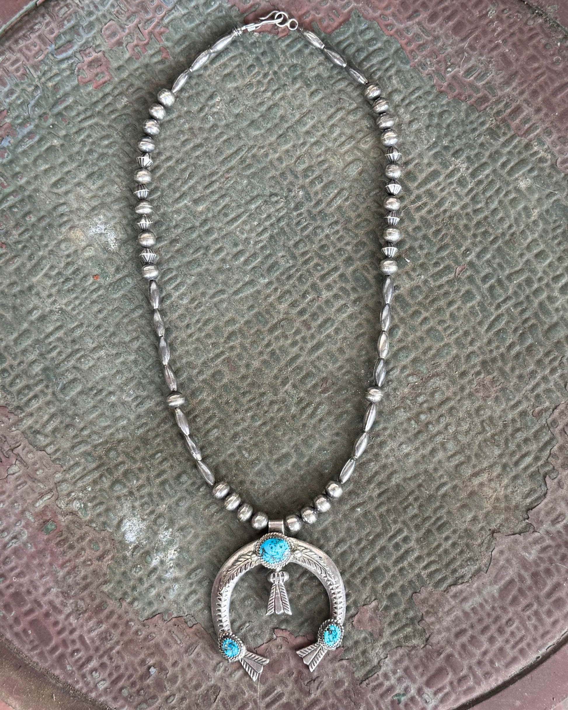 Front of Old Pawn Silver Bead Necklace with Removable Turquoise Naja — Circa 1970s on rustic metal table top.