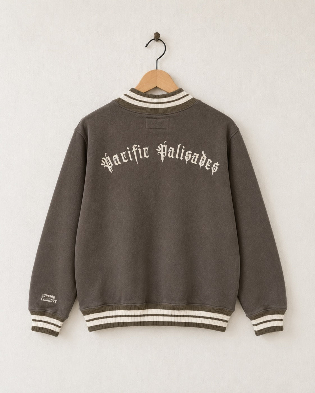 Back view of the mocha brown half-zip sweatshirt highlighting cream embroidered Old Californio typography reading Pacific Palisades curved across the upper shoulders.