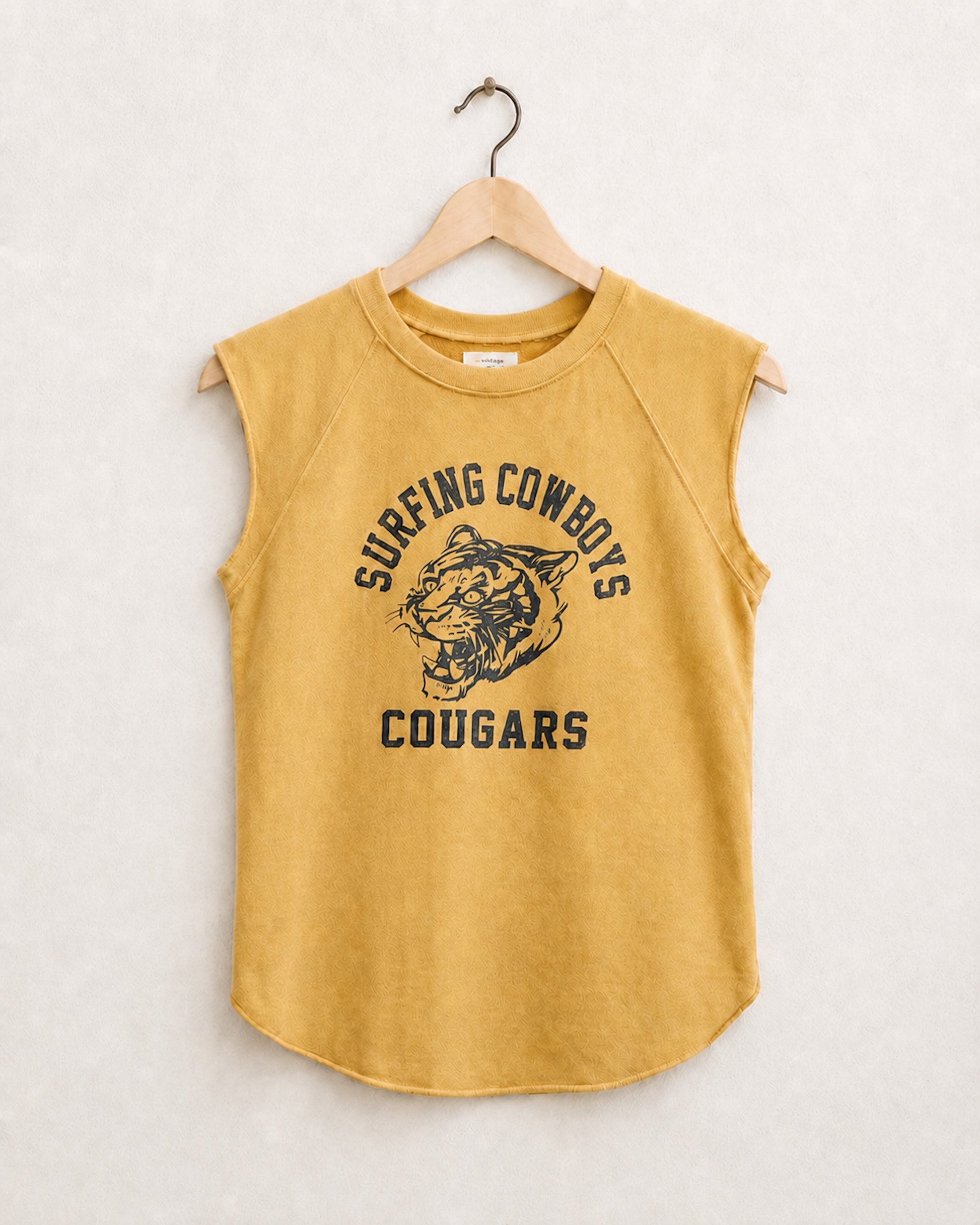 Yellow sleeveless shirt with 'Sureng Cowboys Cougars' text and graphic on a hanger against a light background