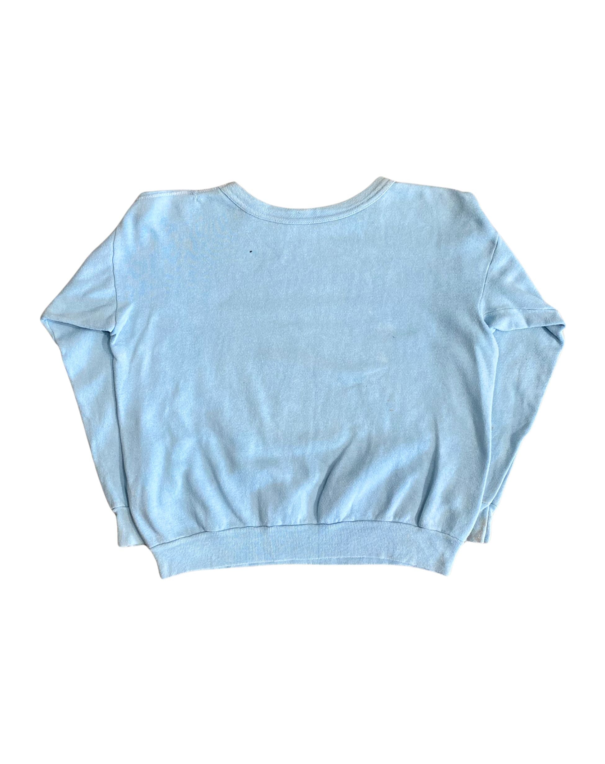Back view of plain light blue 1970s sweatshirt with ribbed hem and sleeves.