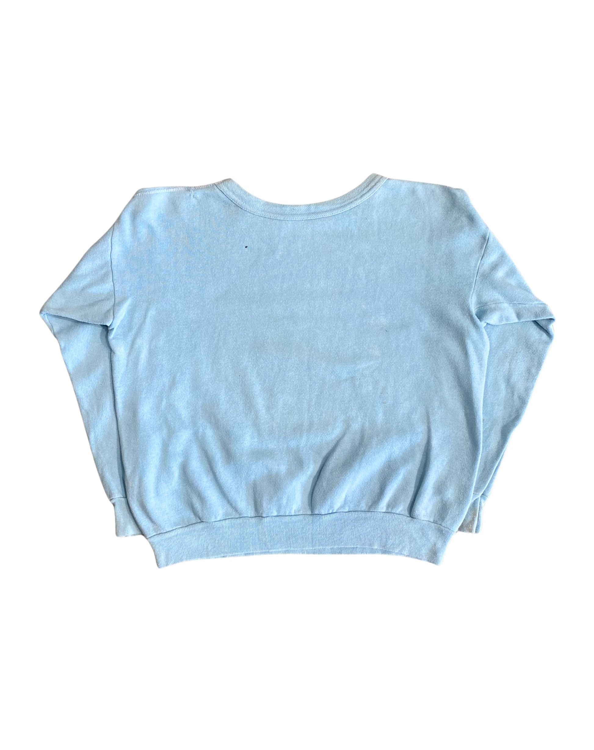 Back view of plain light blue 1970s sweatshirt with ribbed hem and sleeves.