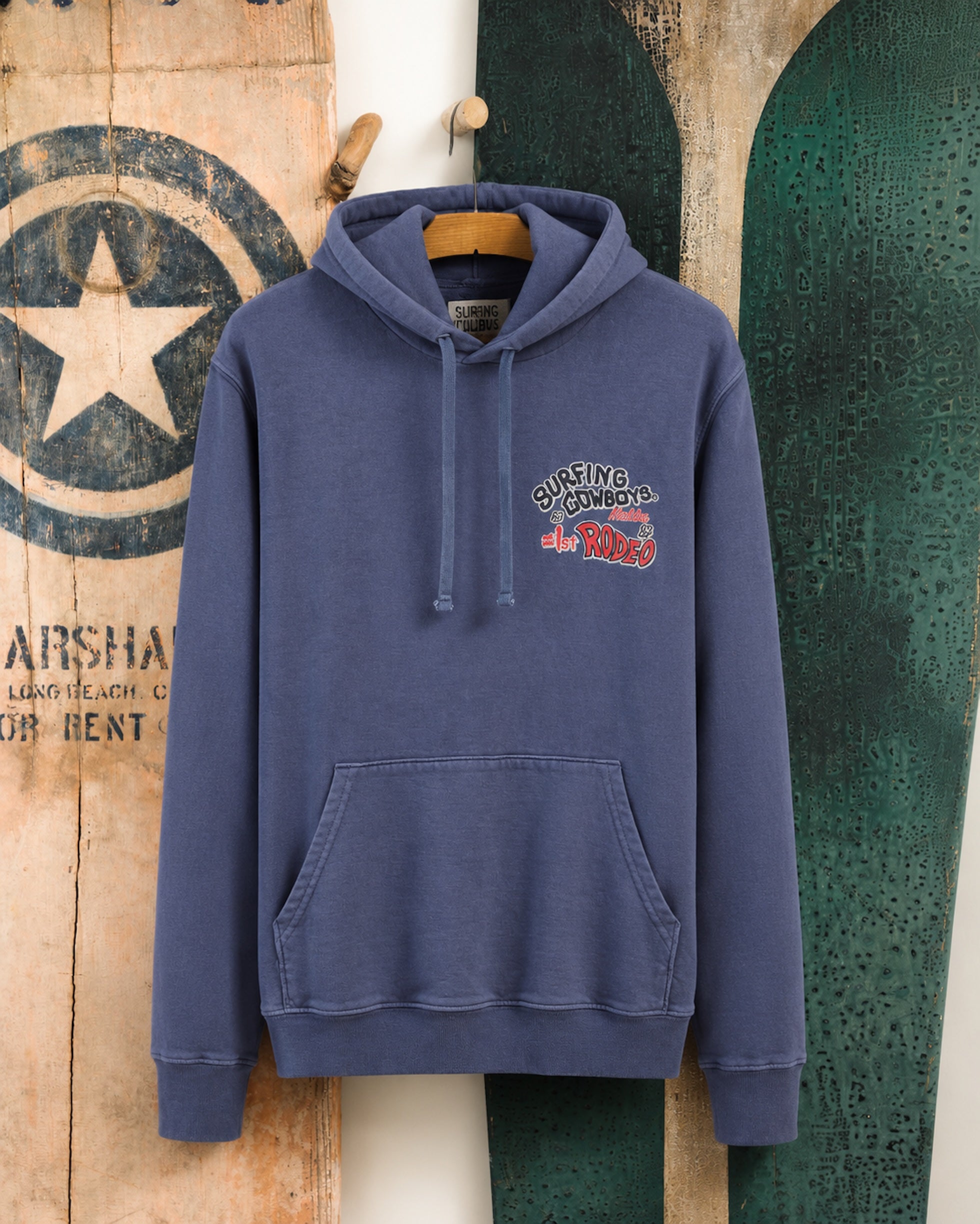 Surfing Cowboys Rodeo pull-over hoodie in washed navy, front view with small left-chest Rodeo graphic.