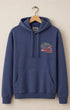 Blue hoodie with a colorful graphic on a beige background