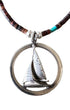 Close-up of sterling sailboat pendant in round frame, showing sculptural detail and patina.