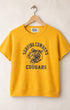 Yellow sweatshirt with 'Surfing Cowboys Cougars' text and tiger graphic on a hanger against a beige background
