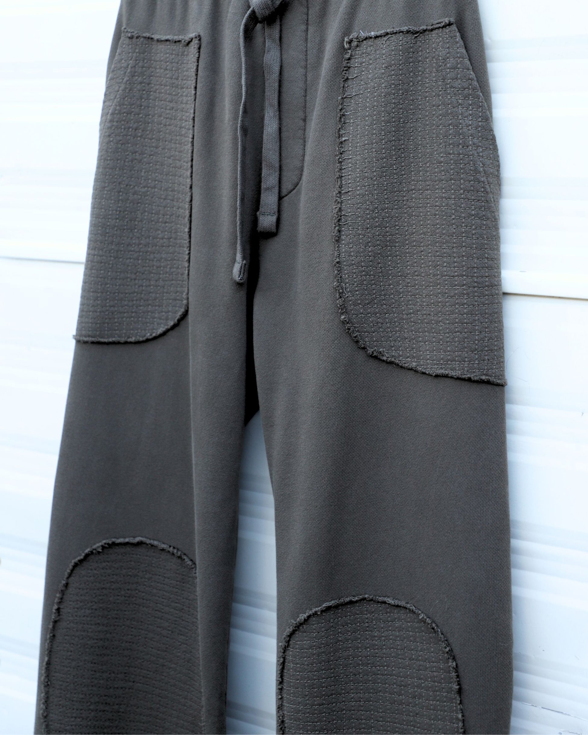 Detail of hand-stitched front pocket panel in crosshatched pattern.
Close-up of reinforced hand-stitched knee patch.