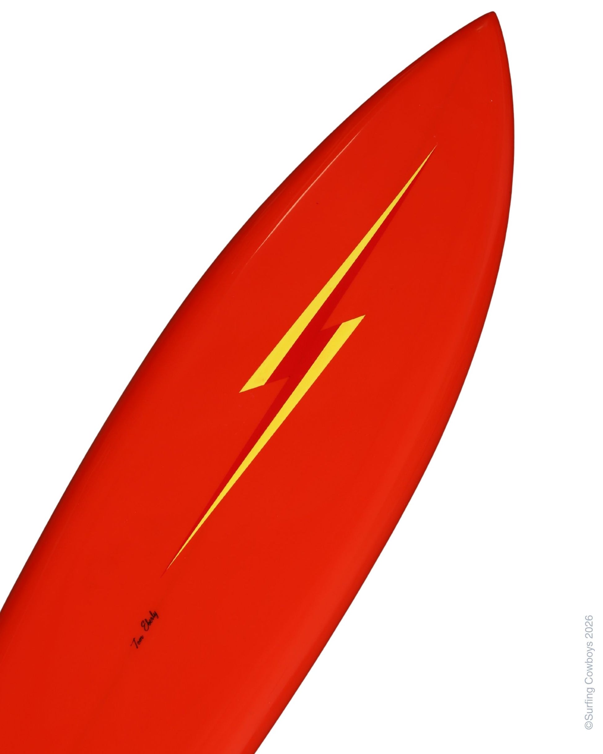 Close-up of yellow Lightning Bolt graphic against saturated red surfboard finish.