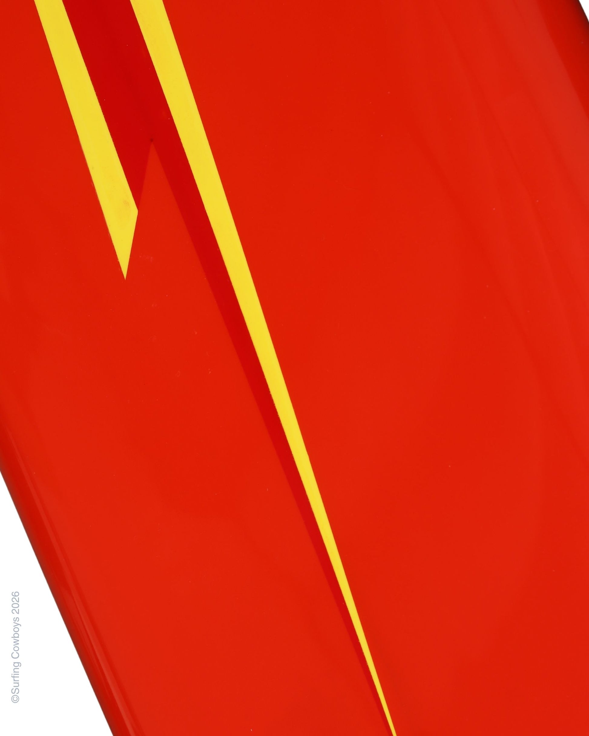 Detail of elongated yellow Lightning Bolt graphic on restored red vintage surfboard.