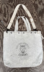 Flat front view of Surfing Cowboys Demons tote with handles and crossbody strap.