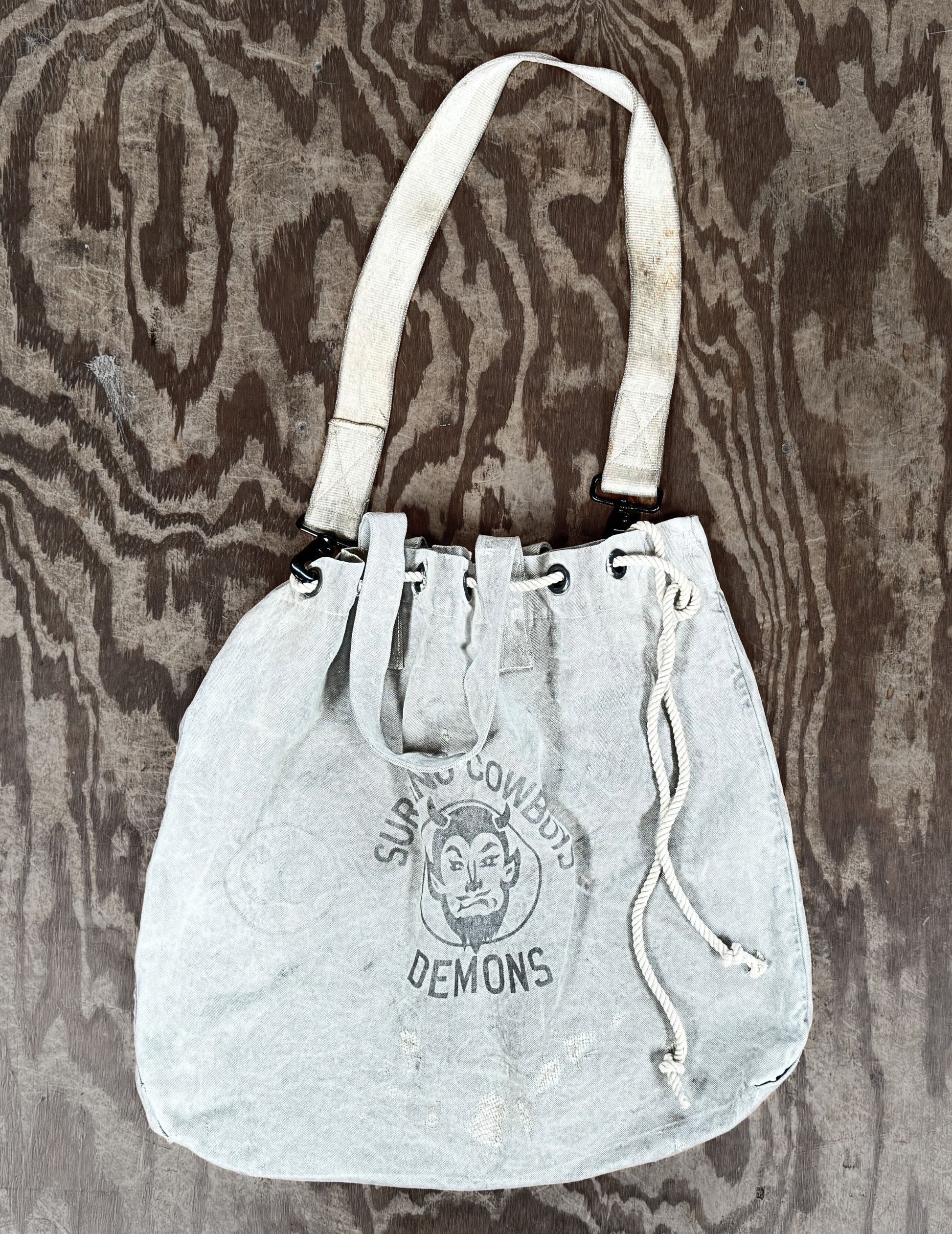 Front view of Surfing Cowboys Demons tote bag with cinch closure.