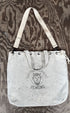 Top view of Surfing Cowboys Demons canvas tote bag showing strap hanging naturally.