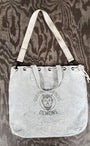 Top view of Surfing Cowboys Demons canvas tote bag showing strap hanging naturally.
