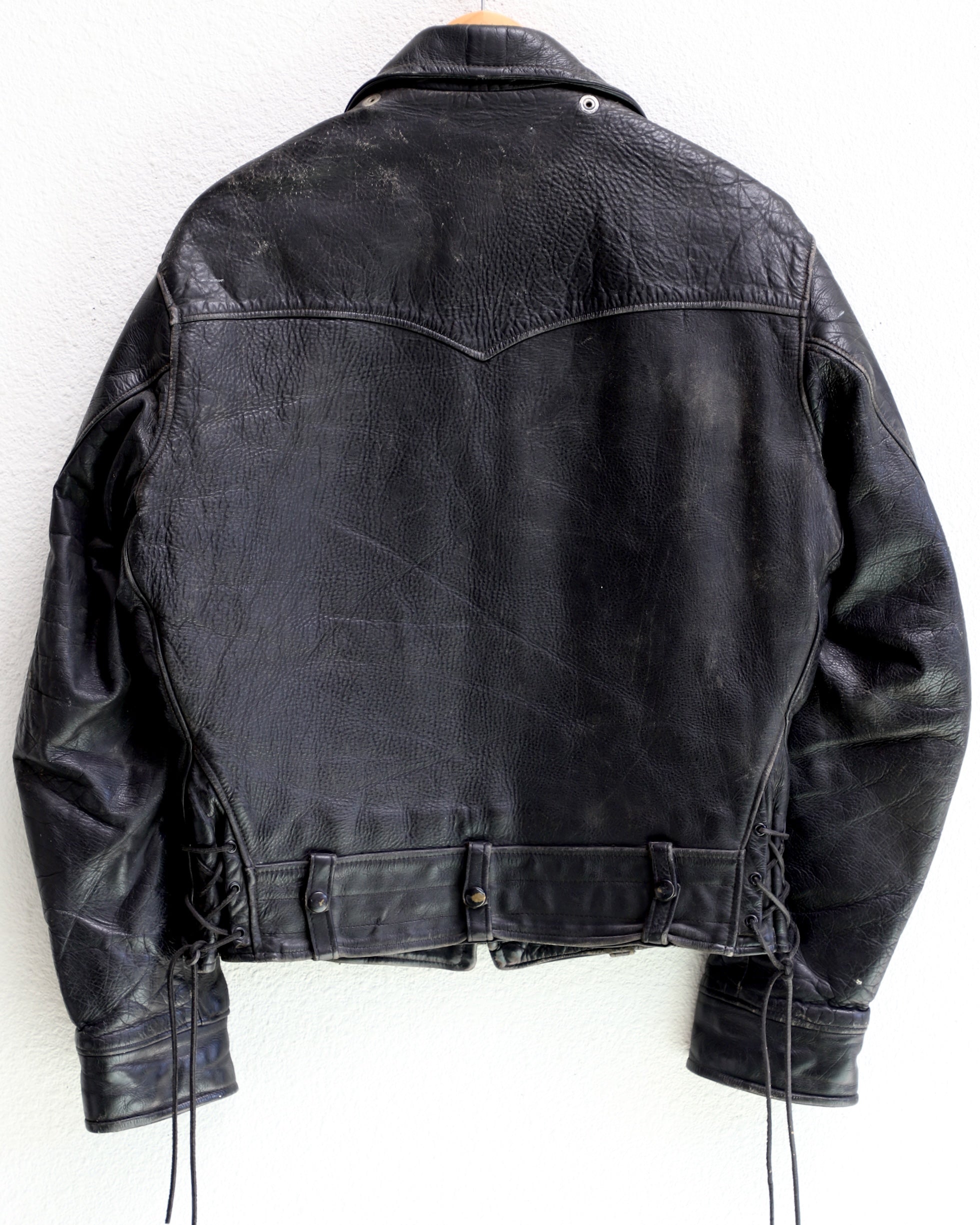 Back of 1950s Taubers black horsehide leather jacket with lace-up sides, Western-inspired yoke, and visible signs of wear.
