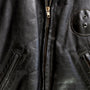 Details of zipper and leather patch 1950s Taubers black horsehide leather jacket with lace-up sides, Western-inspired yoke, and visible signs of wear.
