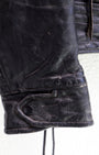 cuff and snap detail 1950s Taubers black horsehide leather jacket with lace-up sides, Western-inspired yoke, and visible signs of wear.
