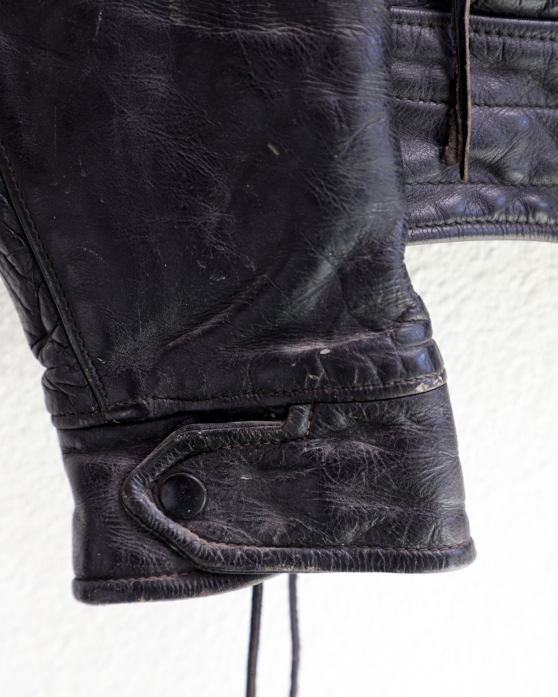 cuff and snap detail 1950s Taubers black horsehide leather jacket with lace-up sides, Western-inspired yoke, and visible signs of wear.
