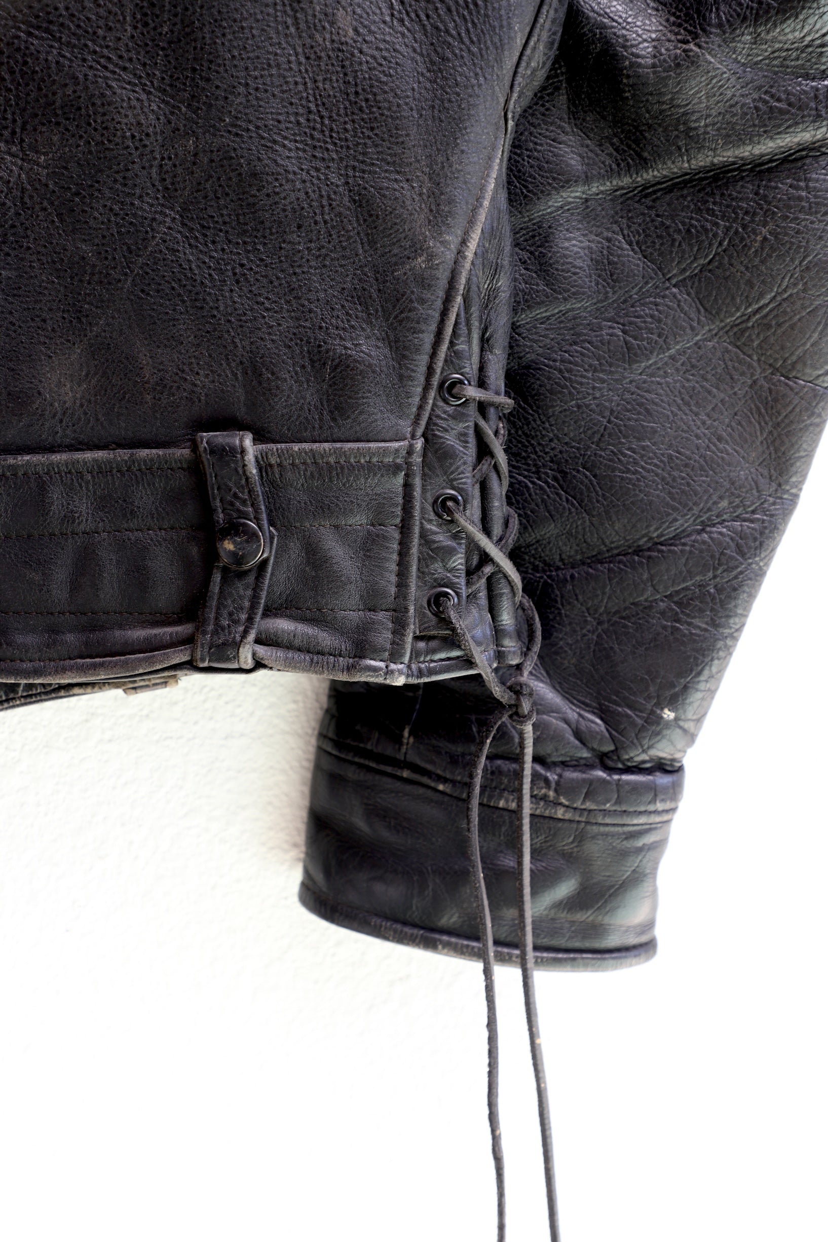 Lace up detail 1950s Taubers black horsehide leather jacket with lace-up sides, Western-inspired yoke, and visible signs of wear.
