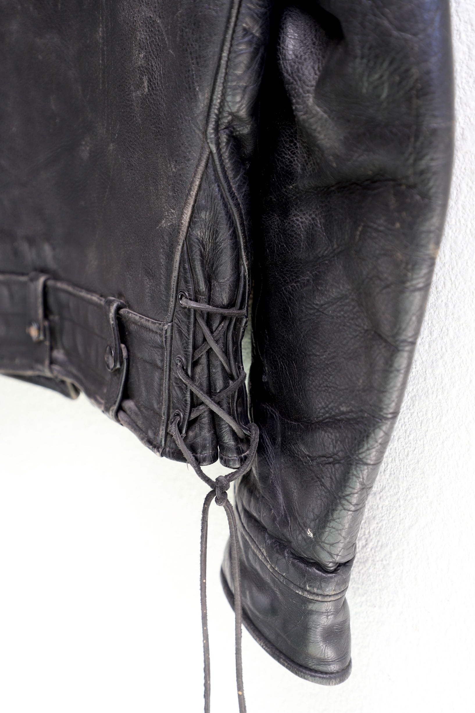 Lace and sleeve detail 1950s Taubers black horsehide leather jacket with lace-up sides, Western-inspired yoke, and visible signs of wear.
