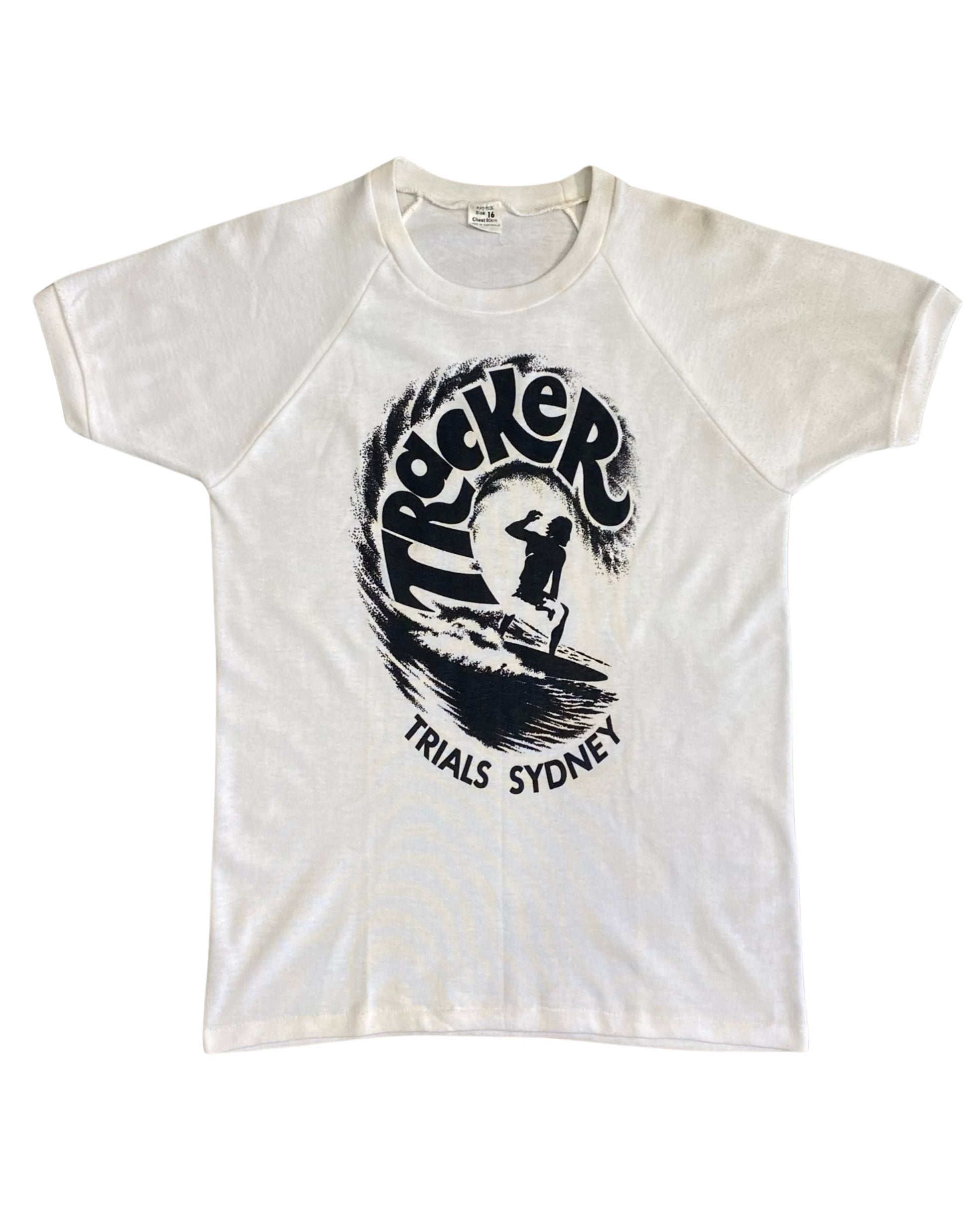 Front of 1970s Tracker Trials Sydney surf T-shirt with black wave and surfer graphic.
