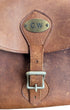 Close-up of brass CW monogram plate and buckle.