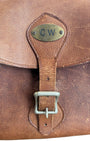 Close-up of brass CW monogram plate and buckle.