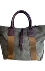 Vintage olive green canvas military tote with brown leather handles and webbing straps, interior zip pocket shown. Front.