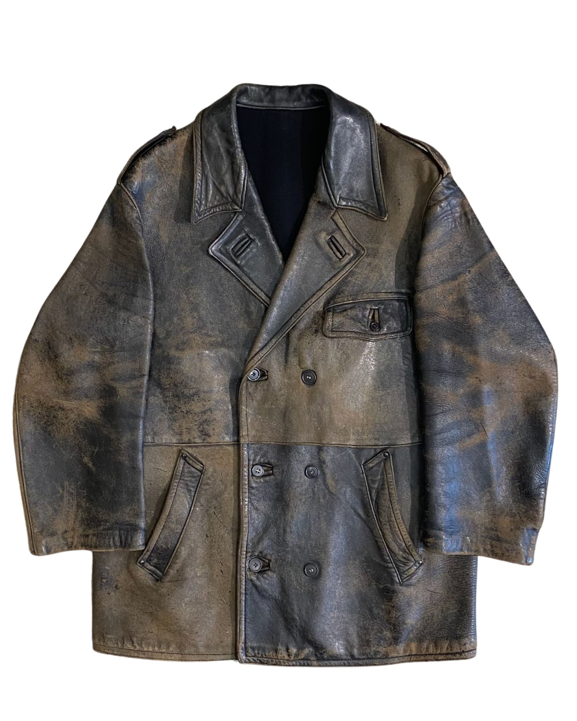 Front view of vintage 1940s Noël Cuir double-breasted leather coat with natural black-to-tobacco patina, shown flat on concrete floor.