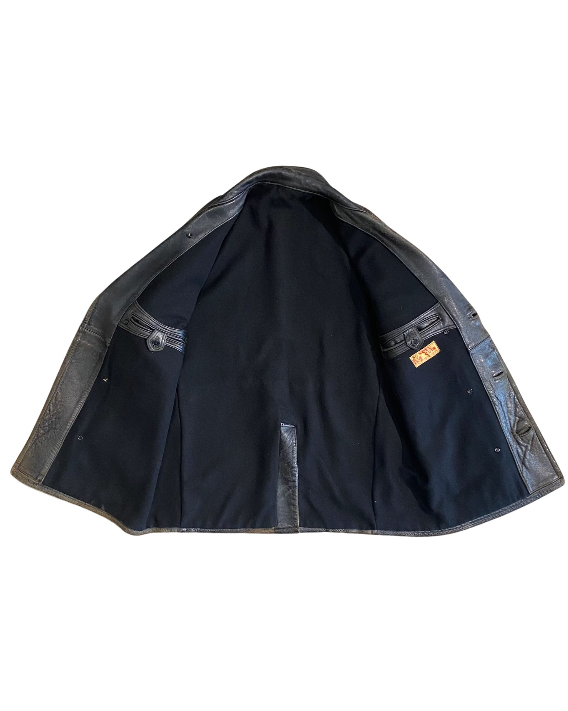 Full interior view of vintage Noël Cuir leather coat showing heavy black wool lining and original label on interior pocket.