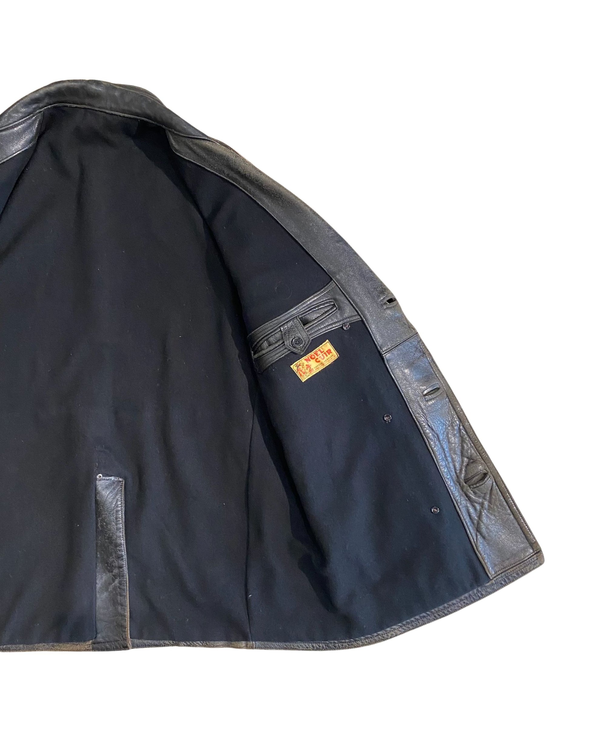 Detail of interior left panel showing leather belt tab construction and black wool lining of vintage Noël Cuir coat.