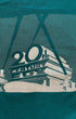 Close-up of 20th Century Fox halftone screen print graphic on green sweatshirt showing aged ink crazing and studio monument logo detail.