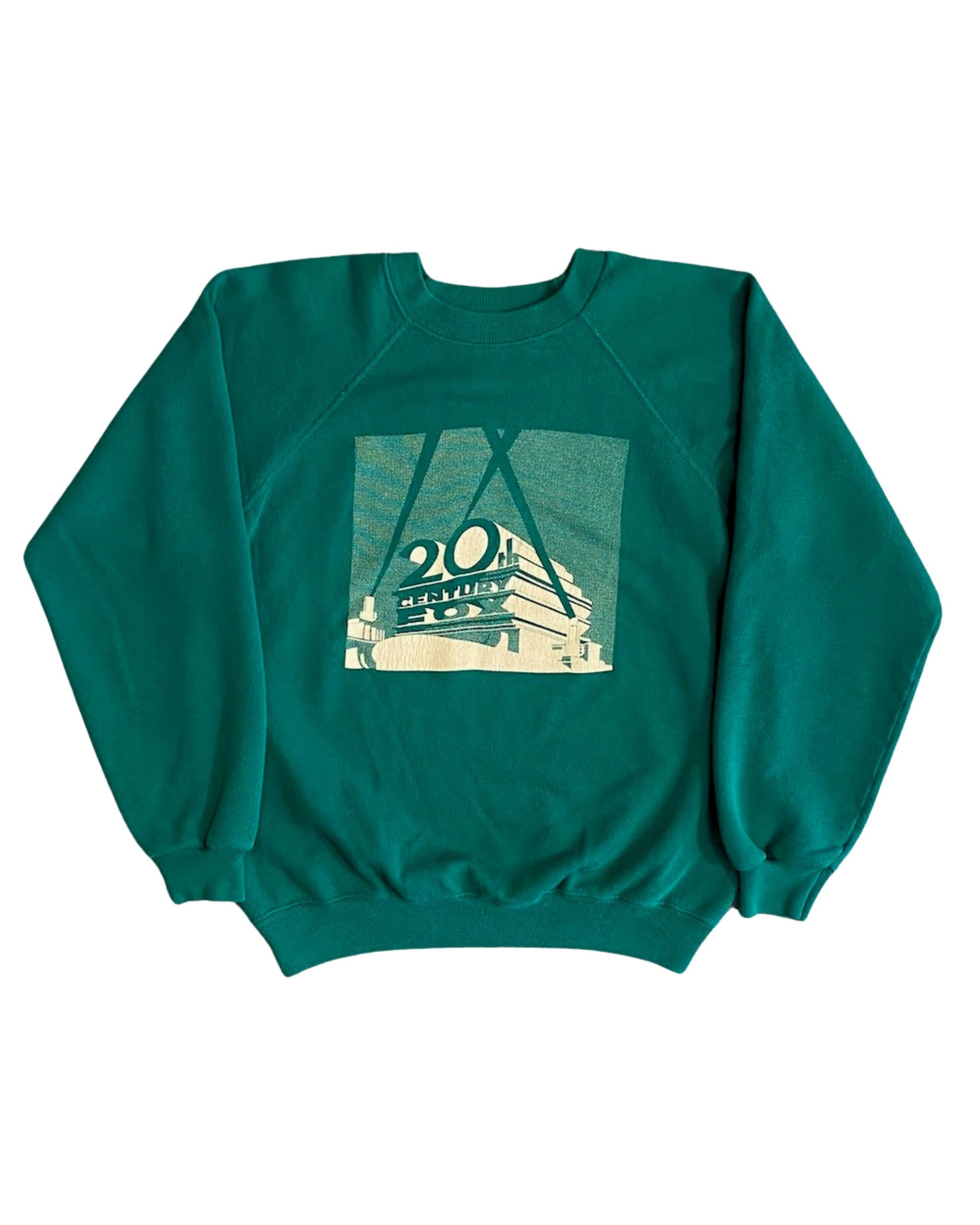 Front view of vintage 1980s 20th Century Fox green raglan crewneck sweatshirt with cream halftone screen print logo graphic, on white background.