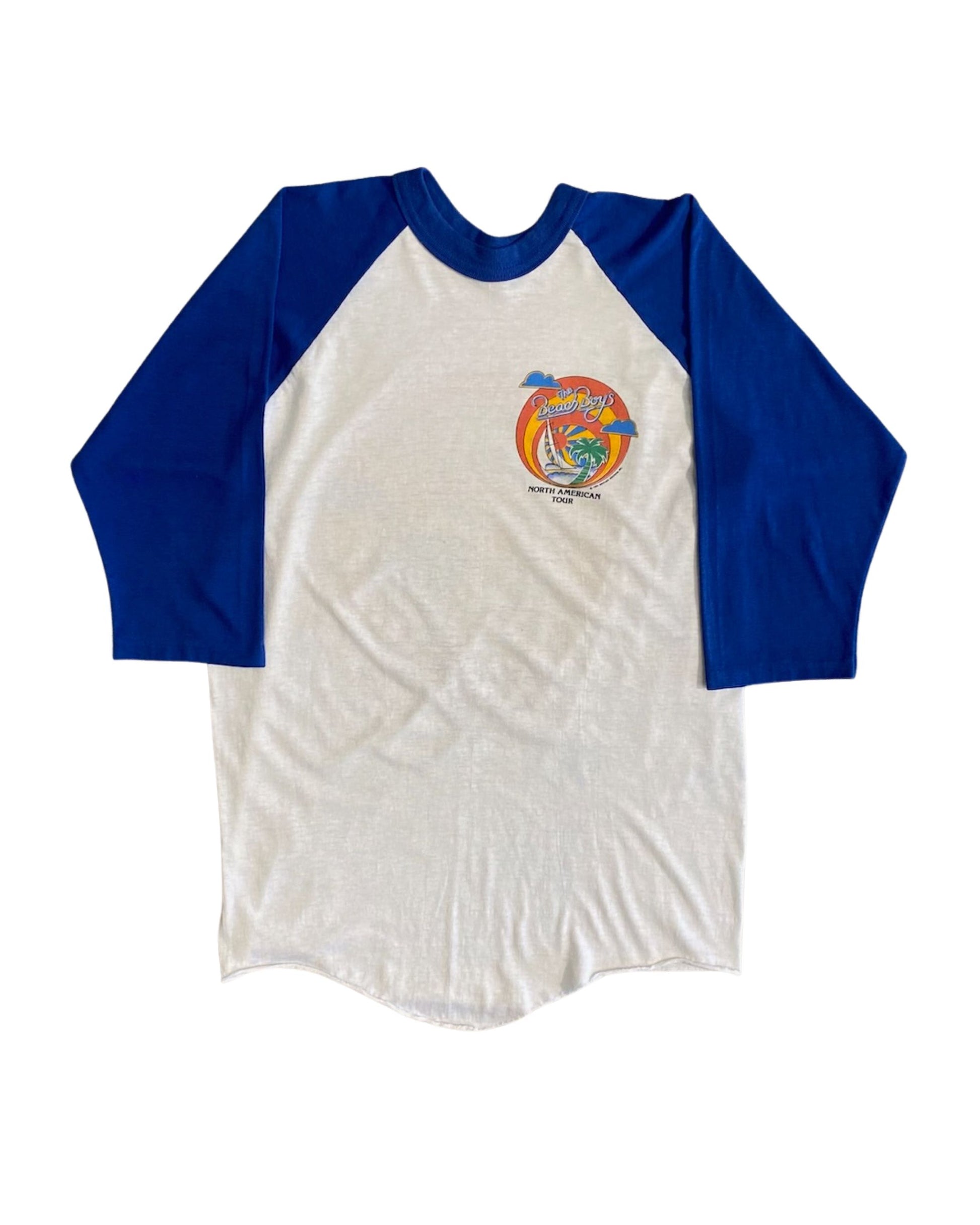 Front view of vintage 1982 Beach Boys North American Tour white and royal blue raglan tee with small chest logo, on white background.