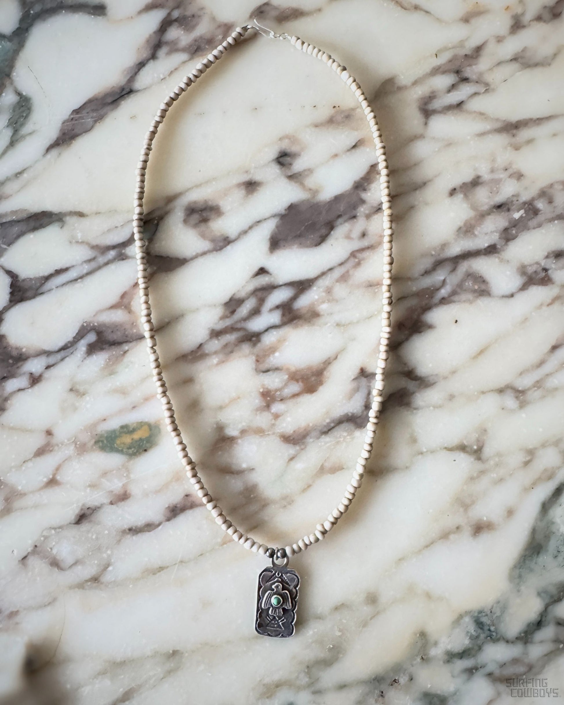 Vintage Fred Harvey Thunderbird tab pendant with turquoise on newly strung ceramic bead necklace.