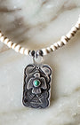 Detail view of vintage Fred Harvey Thunderbird pendant with turquoise on newly strung ceramic bead necklace.