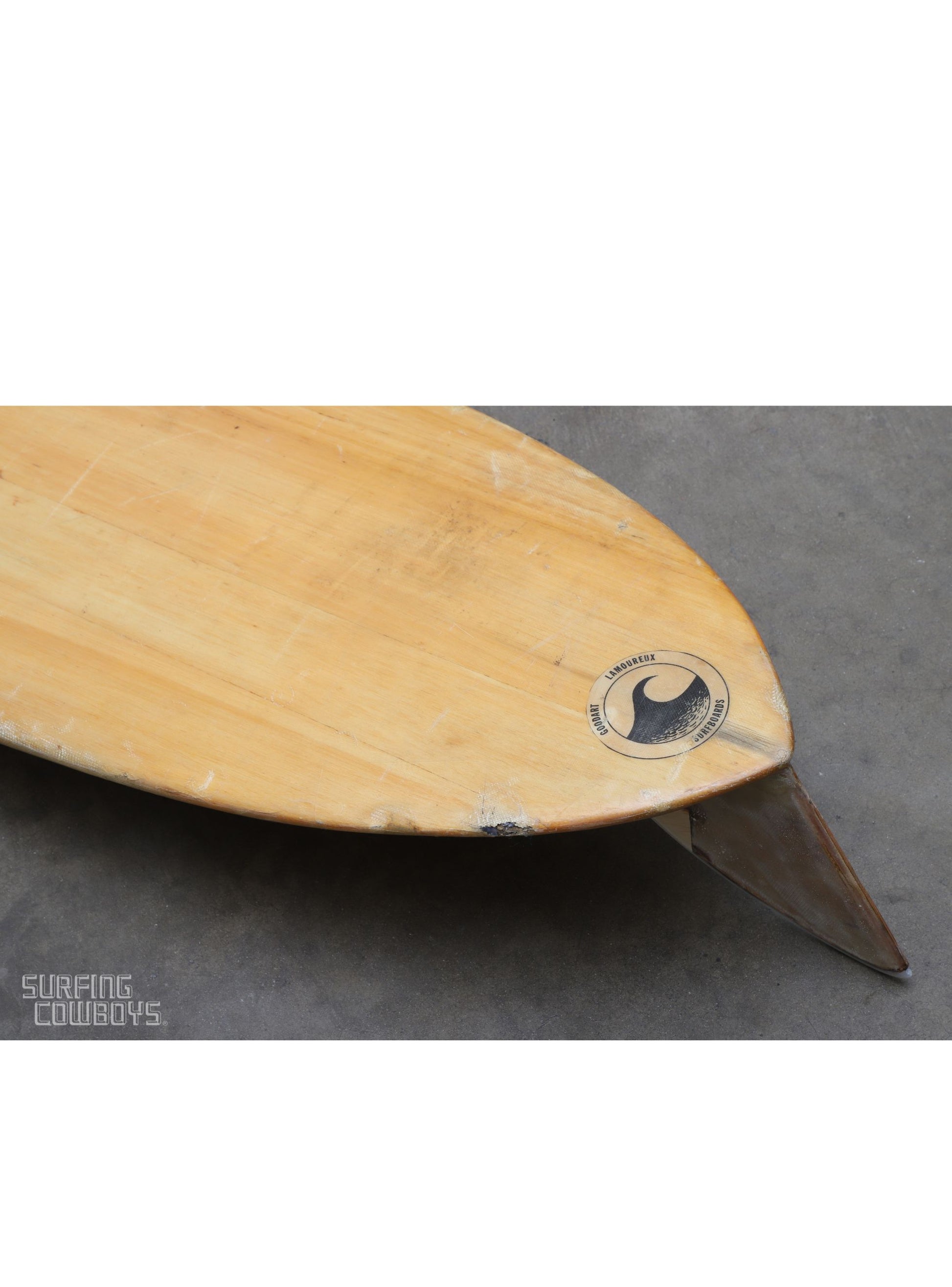 Close up detail of old ding as well as logo on Vintage balsa wood surfboard, 1950s Malibu-made by Goodart & Lamoureux