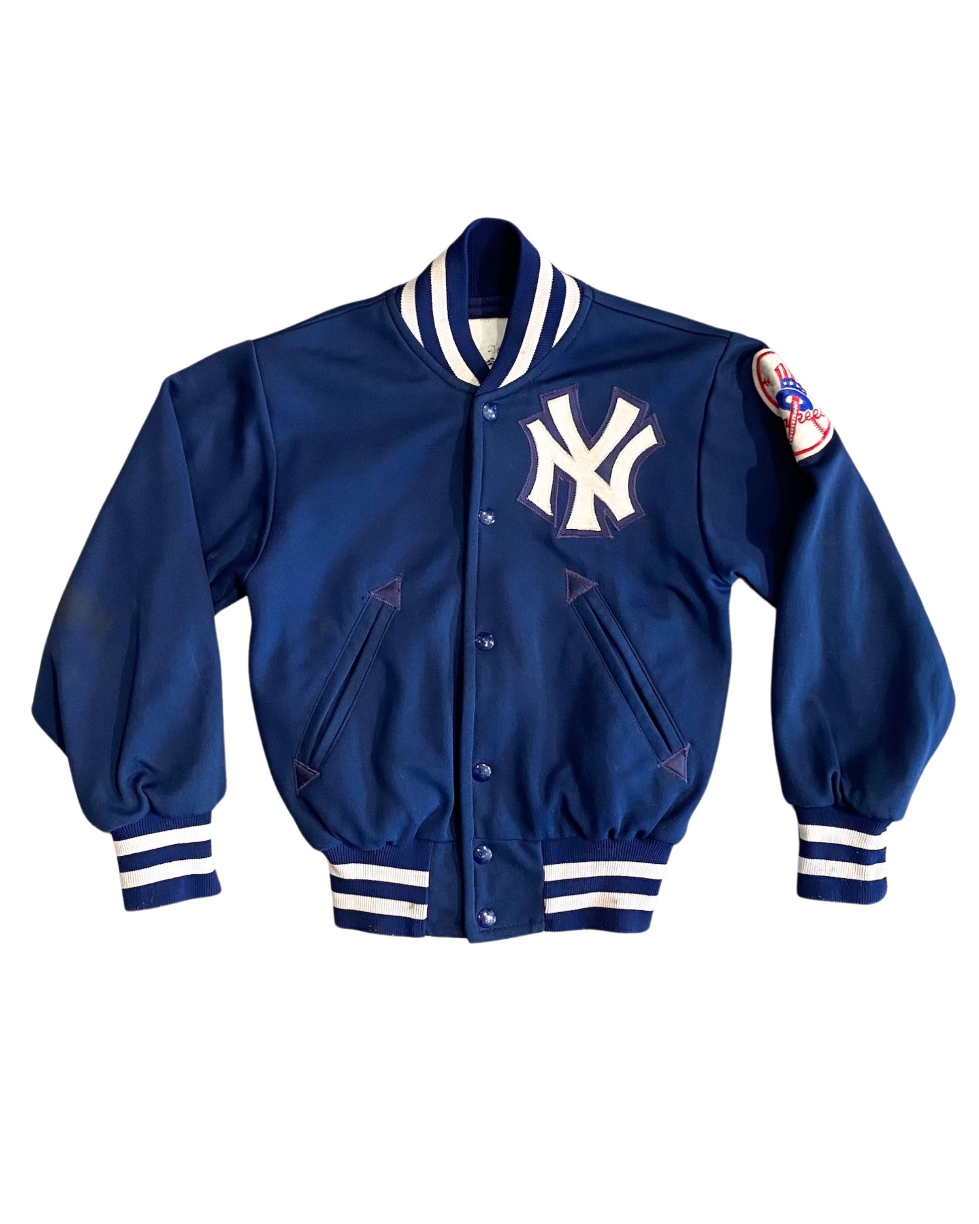 Front of 1960s NY Yankees varsity jacket with logo and striped trim.