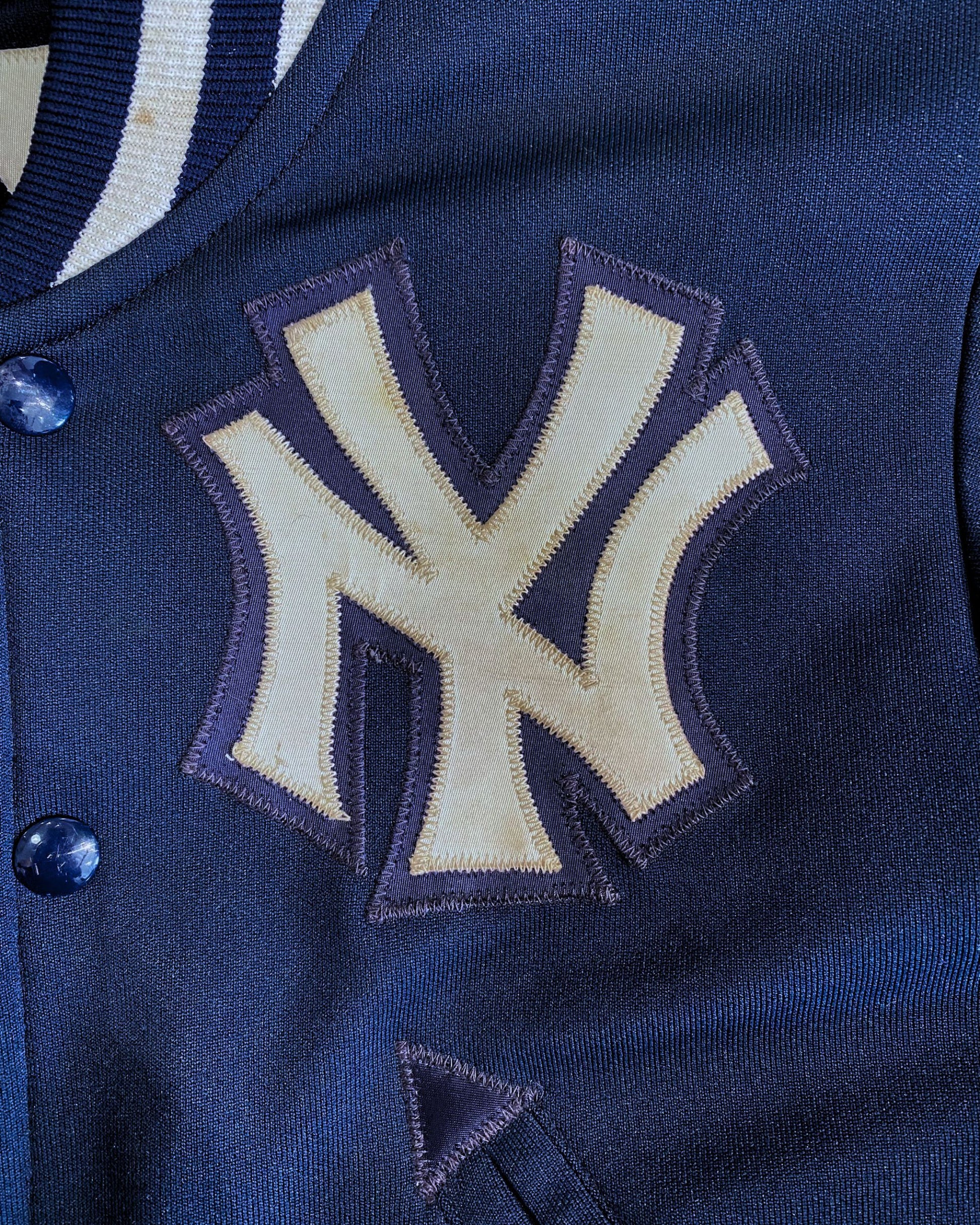 Detail of embroidered Yankees chest logo on varsity jacket.