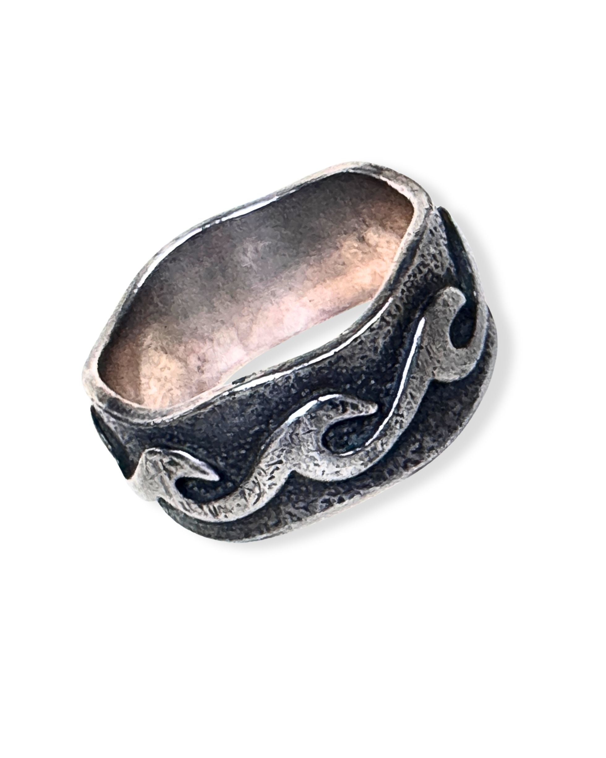 Sterling silver ring with raised scrollwork design and darkened recessed background.