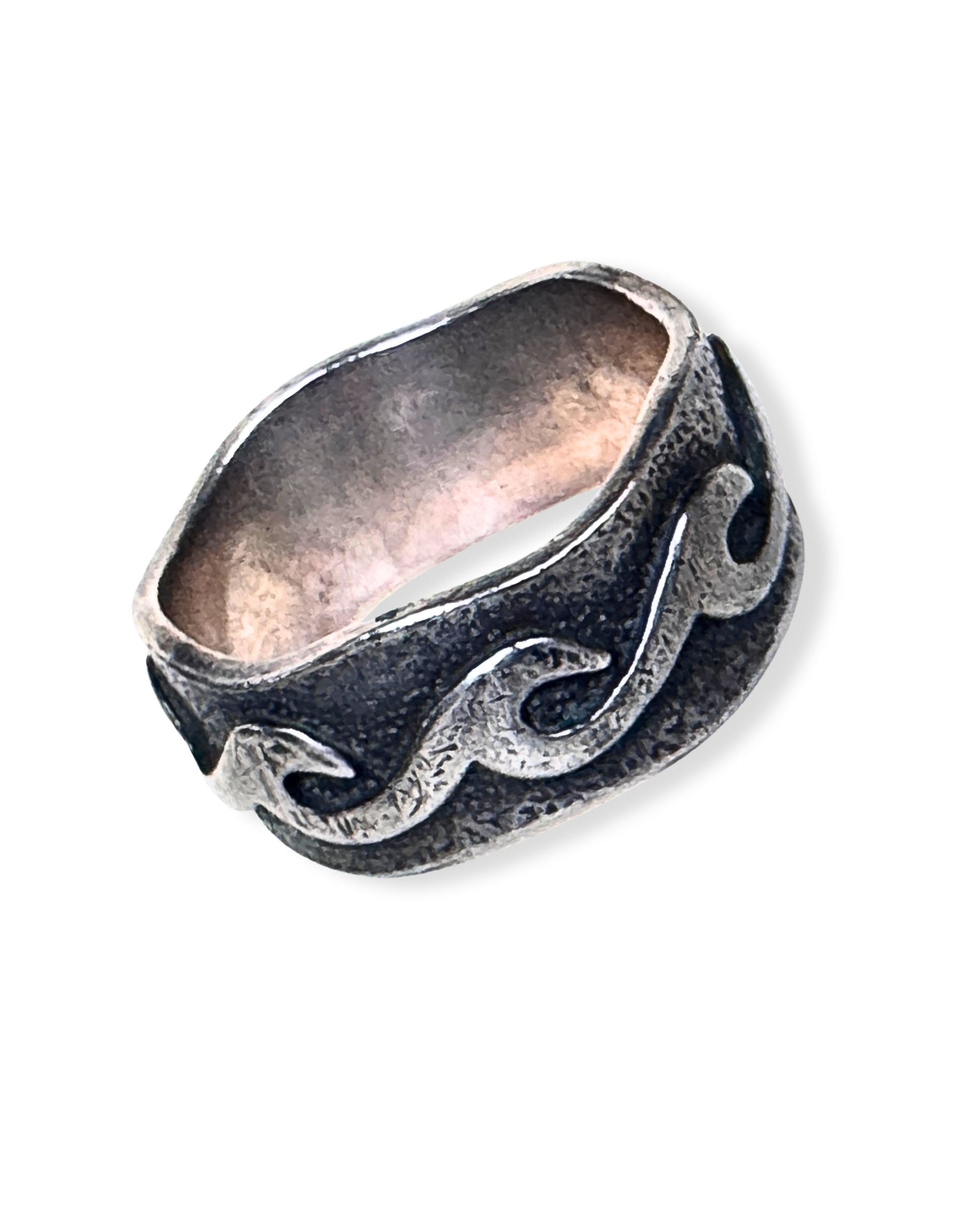 Sterling silver ring with raised scrollwork design and darkened recessed background.