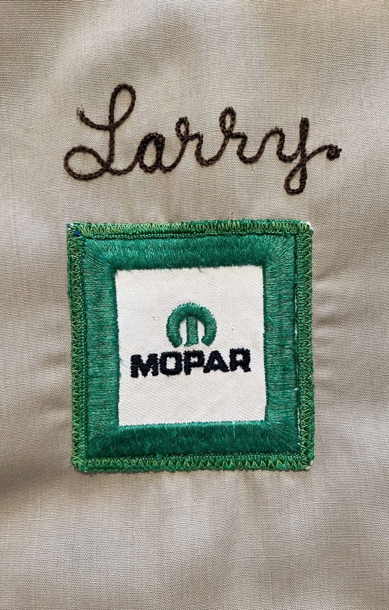 Close-up of green Mopar patch with chainstitched name “Larry” above.