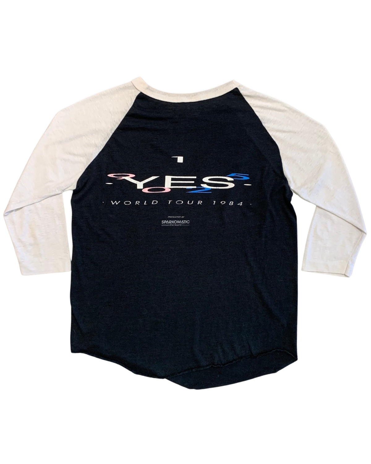 Back view of a black and white three-quarter sleeve YES baseball T-shirt with YES World Tour 1984 and Sparkomatic Car Sound graphics.