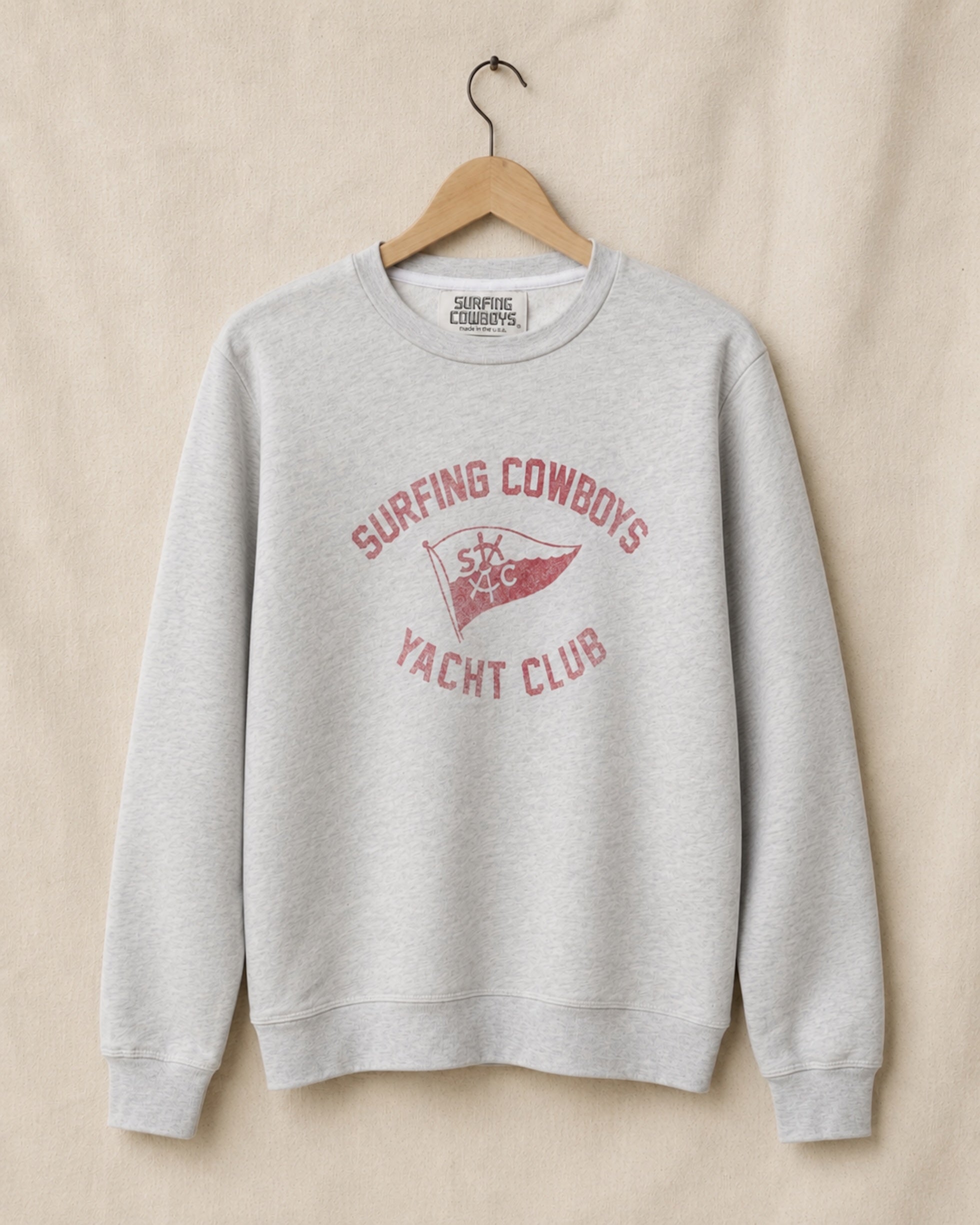 Gray sweatshirt with red text and logo on a beige background