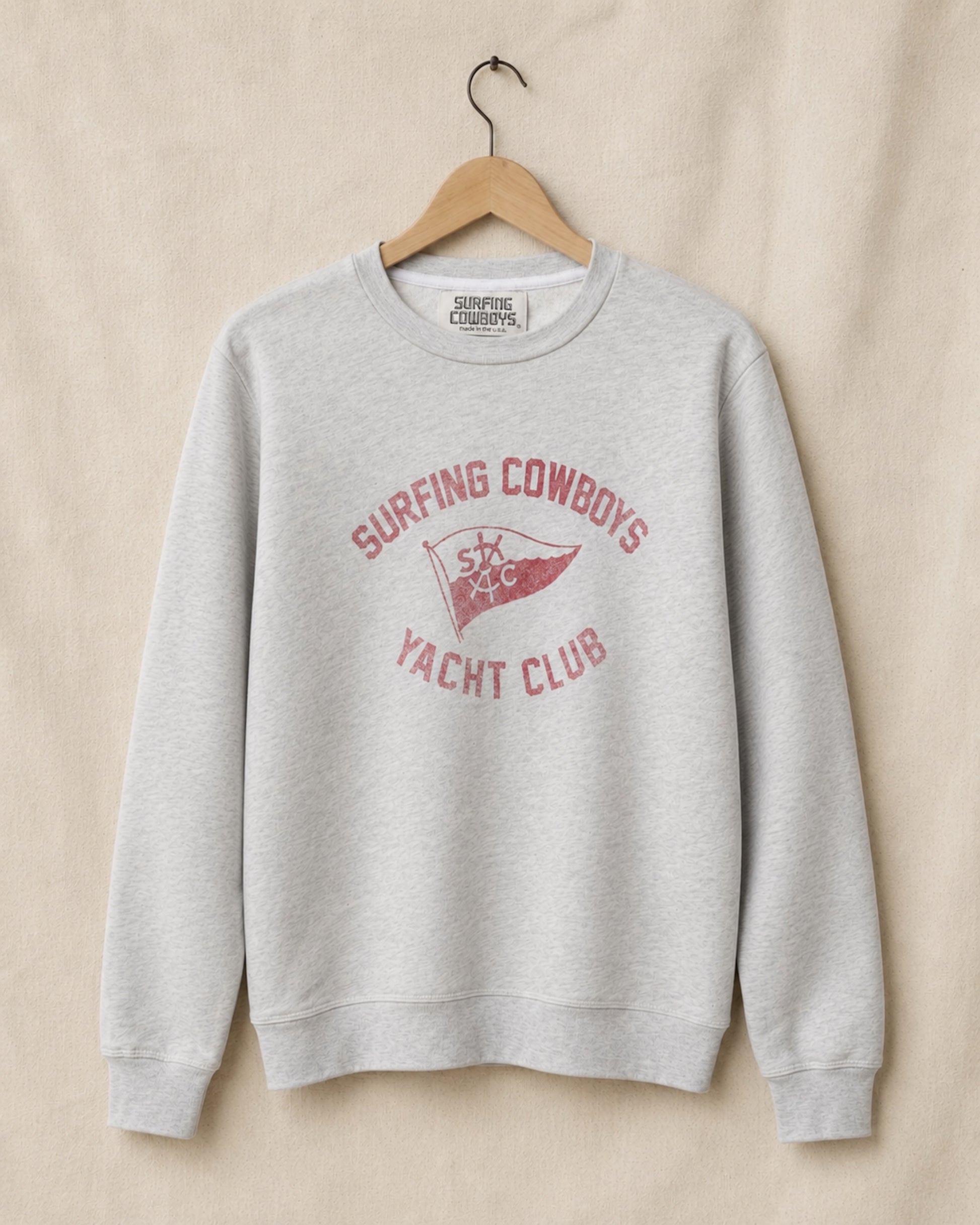 Gray sweatshirt with red text and logo on a beige background