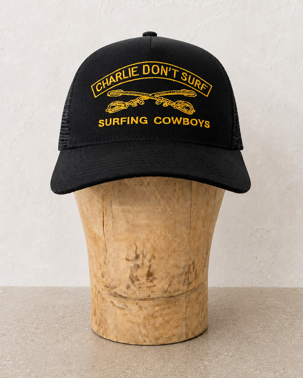 CHARLIE DON'T SURF BLACK AND GOLD CAP ON STAND