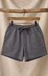 Front of Surfing Cowboys Relaxed Shorts in Loopback Cotton – Dove Grey on hanger in front of canvas background
